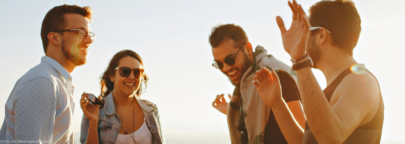 Drei Männer und eine Frau, die lachen